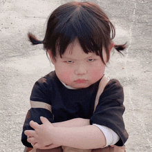 a little girl with pigtails is making a funny face with her arms crossed