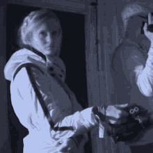a woman in a white jacket is holding a camera with a strap that says ' 00 ' on it