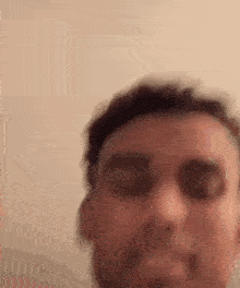 a close up of a man 's face with his eyes closed against a wall .