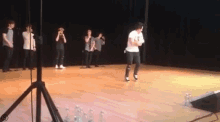 a man is dancing on a stage in front of a group of men .