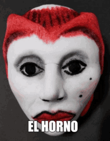 a white face with red hair and the word el horno on it