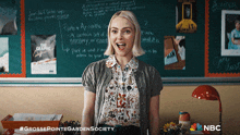 a woman is standing in front of a chalkboard with the words grossepointgardensociety on the bottom