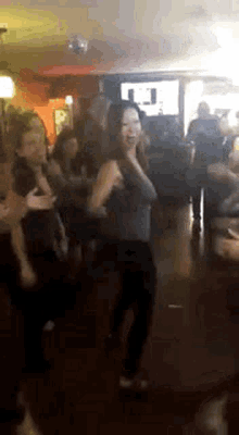 a group of people are dancing together in a room .