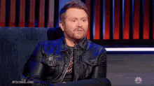 a man with a beard is sitting in a chair with the words songland on the bottom