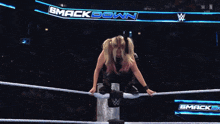 a woman in a wrestling ring with a sign that says smack down on it