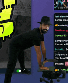 a man with a beard wearing a black hat stands on a chair