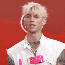a young man wearing a white vest and a pink belt