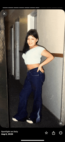 a woman in a crop top and jeans is standing in a hallway with the date aug 6 2020