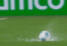 a soccer player is kicking a ball in the water