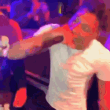 a man in a white shirt is dancing in a crowded room