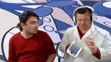 two men wearing headphones are talking to each other in front of a cartoon background