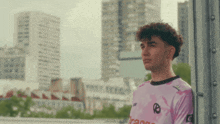 a young man wearing a pink shirt that says " orange " on it