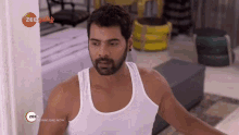 a man with a beard wearing a white tank top with the words zee6 download now on the bottom
