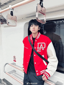 a man wearing a red jacket with a letter a on it