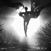 a black and white photo of a person with wings flying in the air