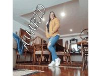 a woman in a yellow jacket is standing in a living room with a sign that says agapio