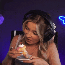 a woman wearing headphones is eating a dessert