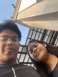 a boy wearing glasses and a girl wearing a black nike shirt