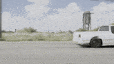 a white pickup truck is driving down a street