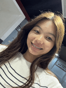 a girl with braces on her teeth takes a selfie in front of a sign that says no parking