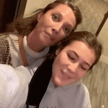 a woman and a girl are posing for a picture .