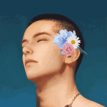 a man with flowers in his hair has his eyes closed and a necklace around his neck