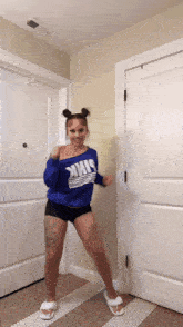 a woman wearing a blue sweater that says ' pink ' on it