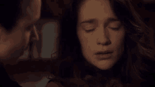 a woman with her eyes closed is talking to another woman .