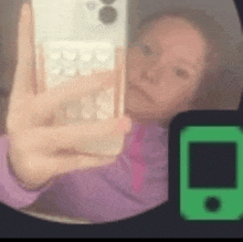 a woman is taking a selfie with her cell phone in a mirror .