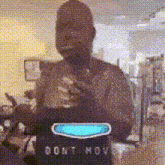 a man is standing in front of a sign that says do not move .