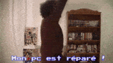 a man stands in front of a bookshelf with the words mon pc est repare on the screen