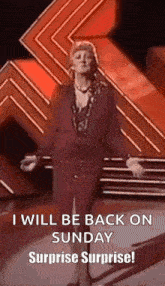 a woman is standing on a stage with her arms outstretched and says `` i will be back on sunday surprise surprise ! ''