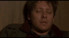 a man is laying on the floor with his eyes closed and his mouth open .