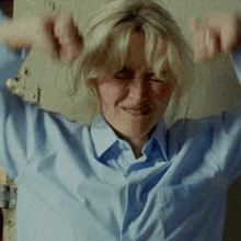a woman in a blue shirt is making a face