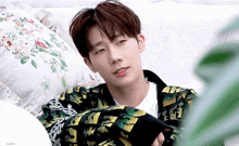 a young man is laying on a couch with a floral pillow behind him and the word brain on the bottom
