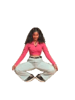 a woman in a pink crop top and white cargo pants stands with her arms outstretched