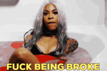 a woman in a bathtub with the words " fuck being broke " on the bottom