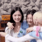 a group of young women are hugging each other and smiling .