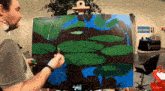 a man is painting a picture of lily pads