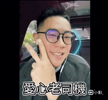 a man wearing glasses is giving the peace sign