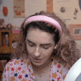 a woman wearing a pink headband and a star print shirt