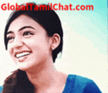 a woman in a blue shirt is smiling in front of a global tamilchat.com banner .