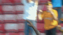 a blurry picture of a man in an orange shirt holding a sword