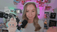 a woman wearing headphones holds a stuffed animal in front of a microphone and a book titled undertale