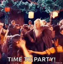 a group of people are dancing in a forest and a man is holding a woman 's hand .