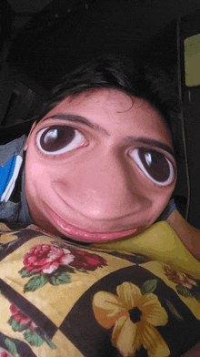 a person laying on a bed with a floral blanket making a funny face