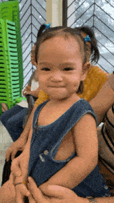 a little girl in a denim dress with pineapples on it