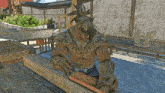 a man with a tattoo on his chest sits at a wooden table working on a piece of wood