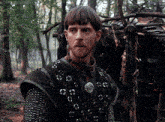 a man in chain mail is standing in the woods with the word tumblr.com in the corner