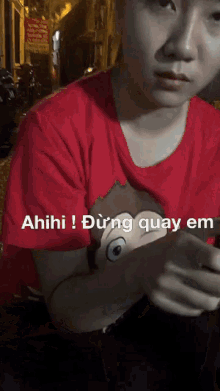 a man wearing a red shirt with a monkey on it says ahihi